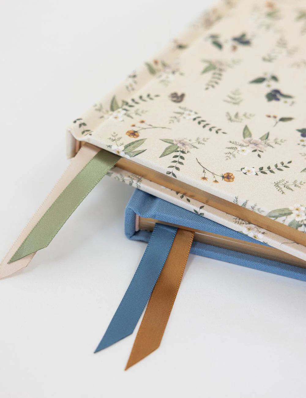 Floral notebook with colorful ribbon bookmarks on a white background