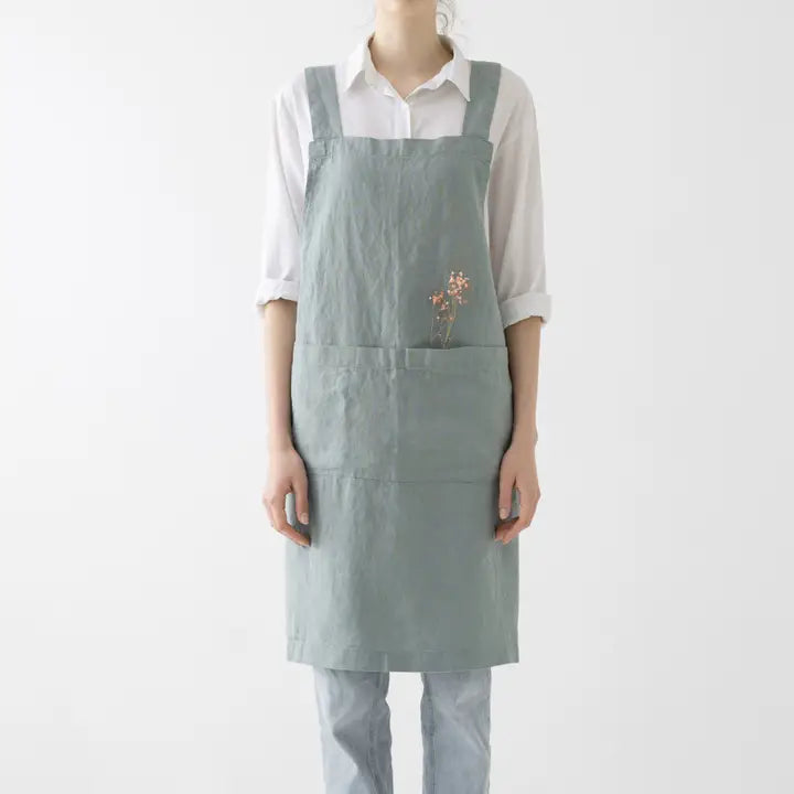 Person wearing a light green apron on a white background