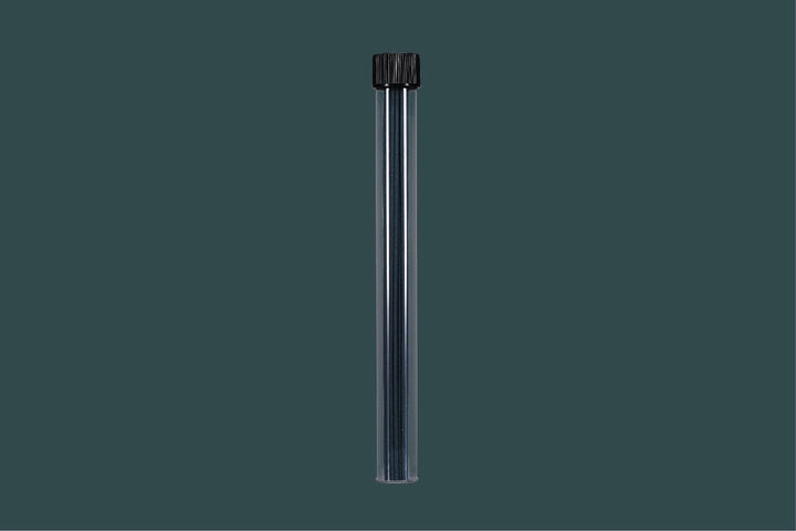 Clear cylindrical container with incense sticks with black cap on a dark gray background