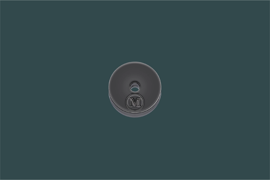 Round metallic button with a logo on a dark green background