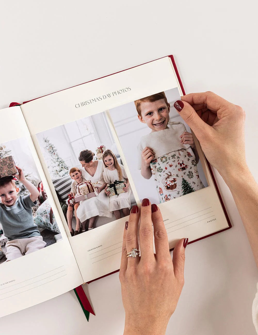Person flipping through a photo album with Christmas-themed pictures.