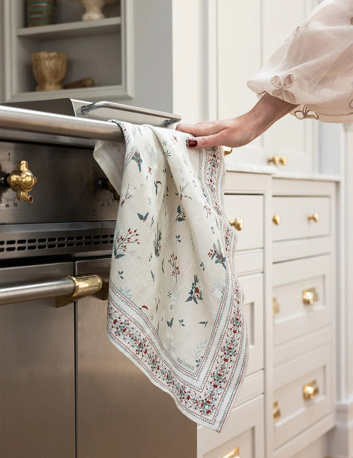 A christmas tea towel draped over oven handle 