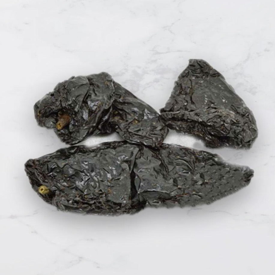 Dried ancho chillies on a white background 
