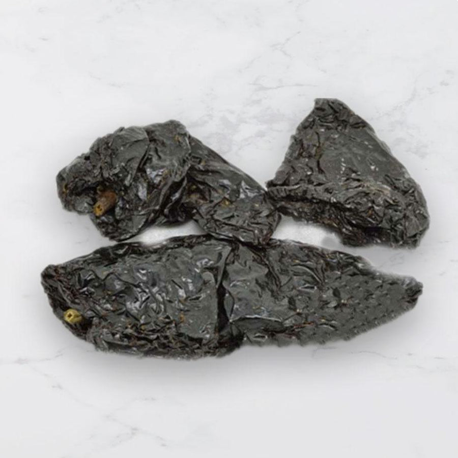 Dried ancho chillies on a white background 