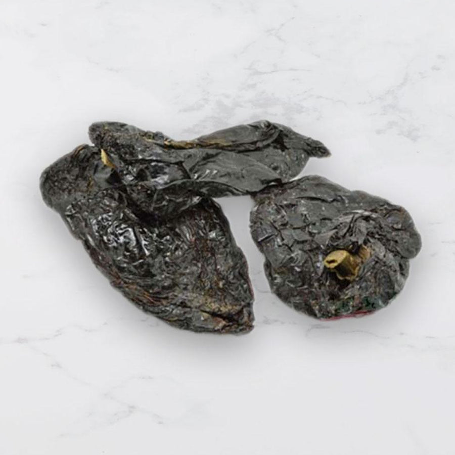 Dried mulato chillies on a light gray background