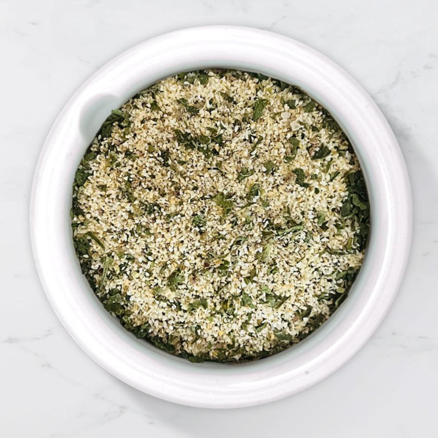 Garlic bread spice mix in a white bowl on a marble background 