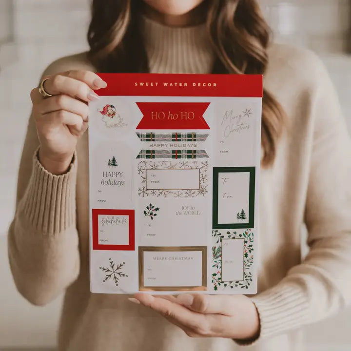 Person holding a package of Sweet Water Decor Christmas stickers
