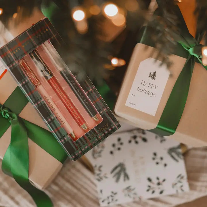Gifts with green ribbons against a blurred Christmas tree background