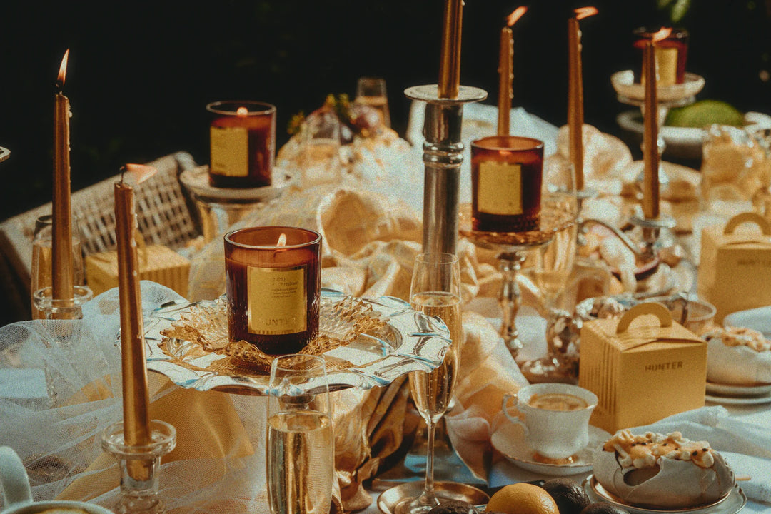 Decorative table setting with candles, glasses, and a box on a dark background