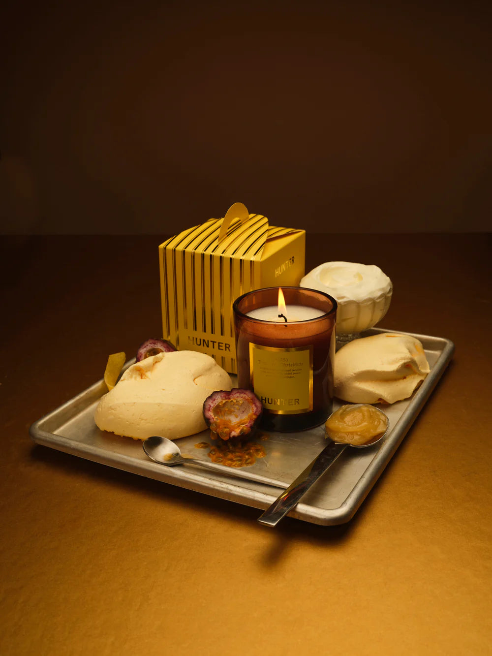 Candle with decorative items on a tray against a dark background