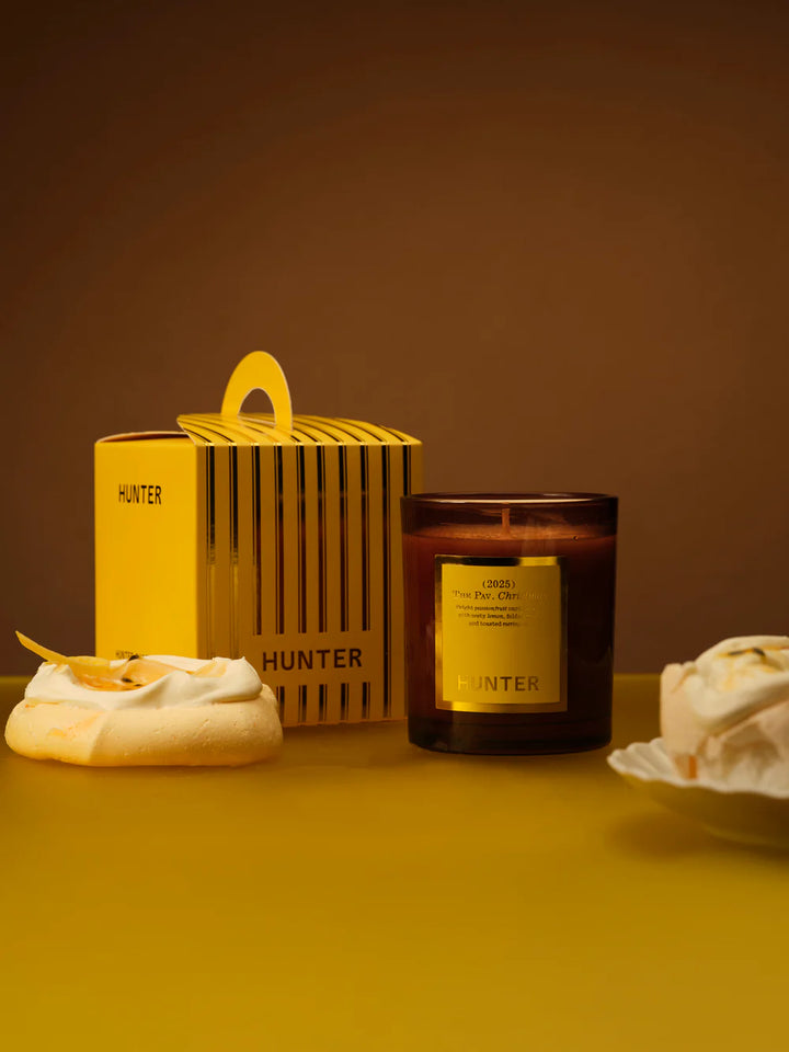 Hunter candle and container on a yellow surface with a brown background