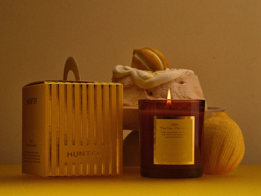 Candle with a decorative box and decorative items on a yellow surface