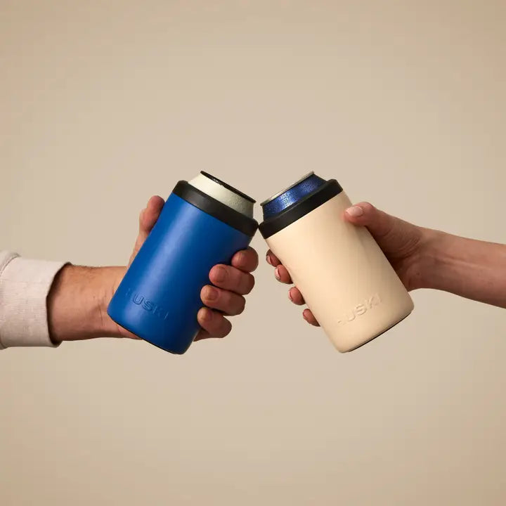 Two hands holding blue and beige travel mugs with a beige background