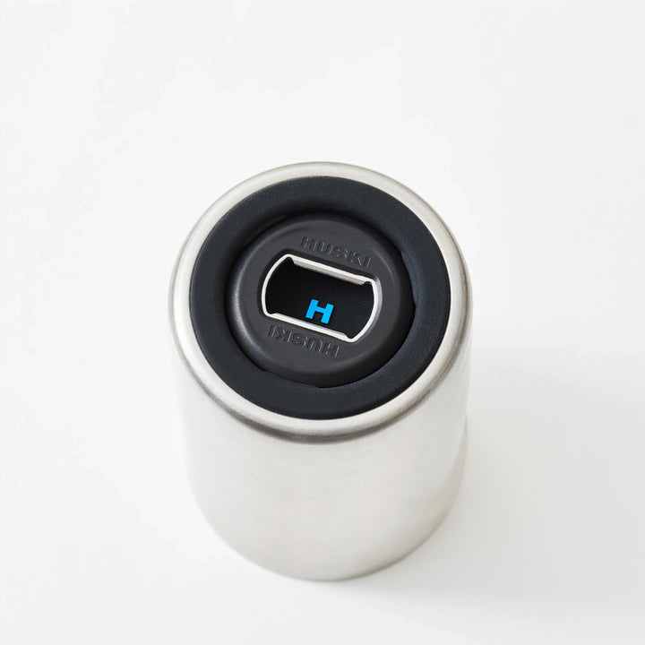 Close-up of a white cylindrical container with a black lid featuring a blue logo on a white background