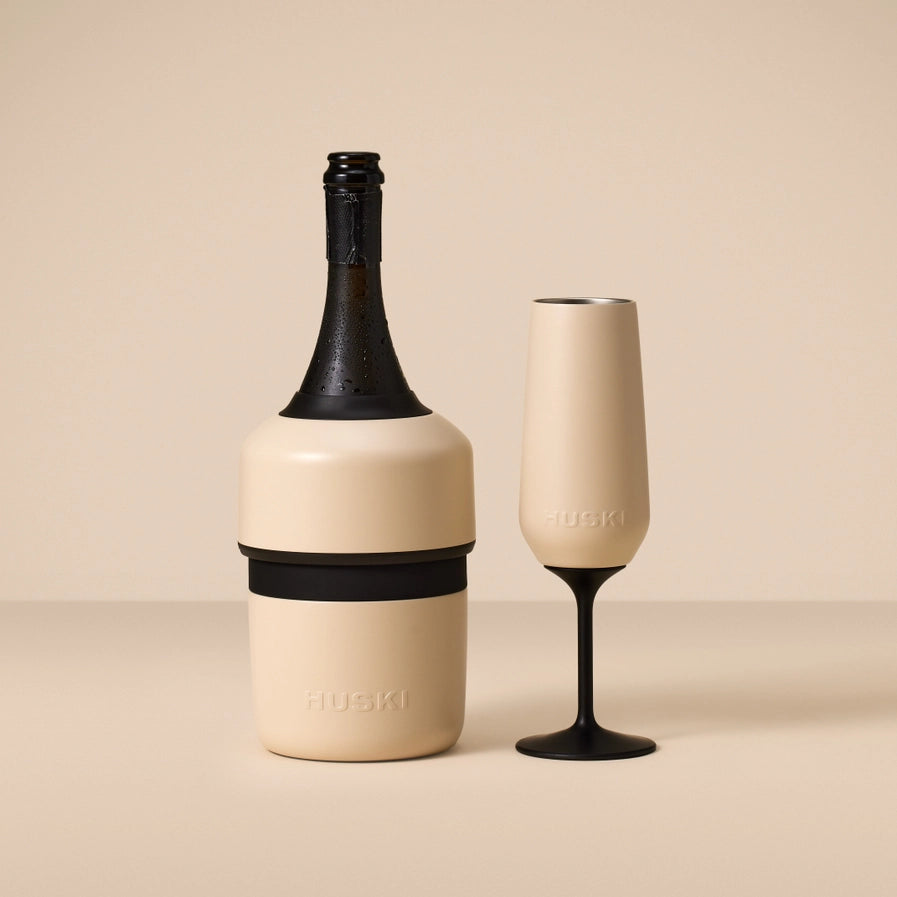 Champagne bottle and glass with 'HUSKI' branding on a beige background