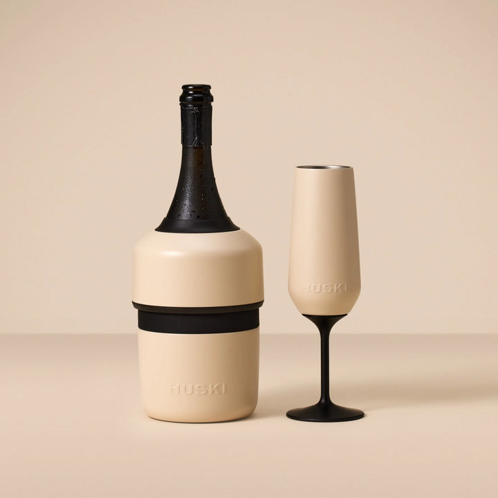 Champagne bottle and glass with 'HUSKI' branding on a beige background
