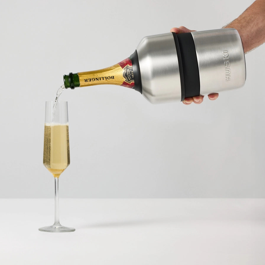 Bottle of champagne being poured into a glass using a Huski champagne cooler.