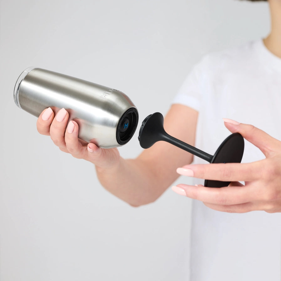 Person holding a silver and black huski champagne tumbler with a black stem