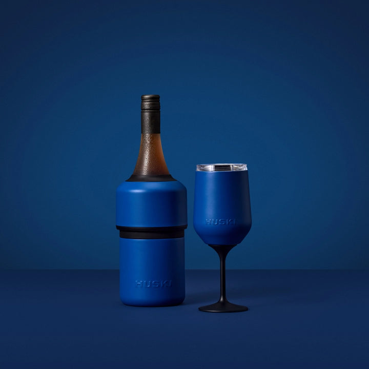 Blue wine bottle cooler and glass on a blue background