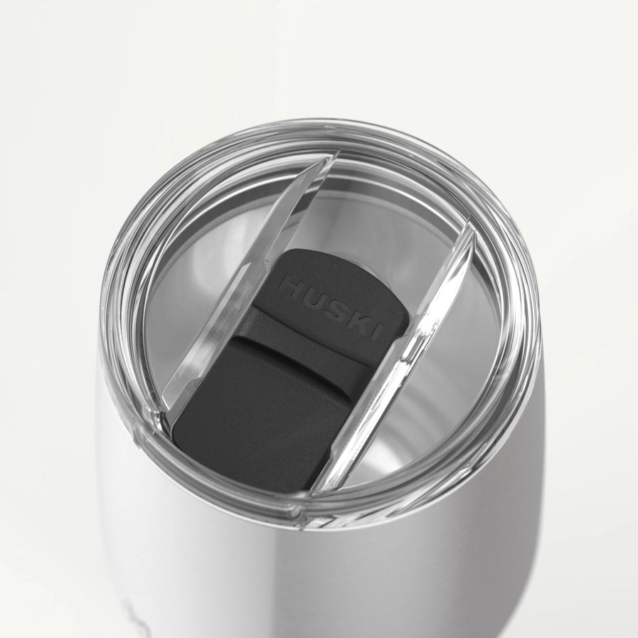 Silver tumbler with a black lid featuring the 'HUSKI' brand on a white background