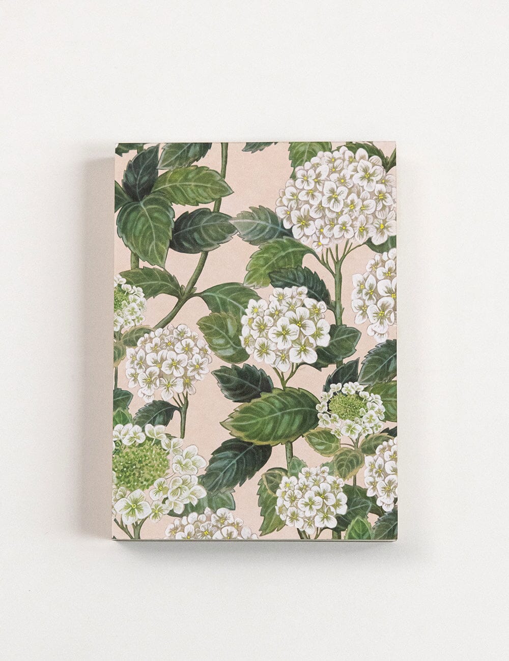 Floral design notebook with green leaves and white flowers on a beige background