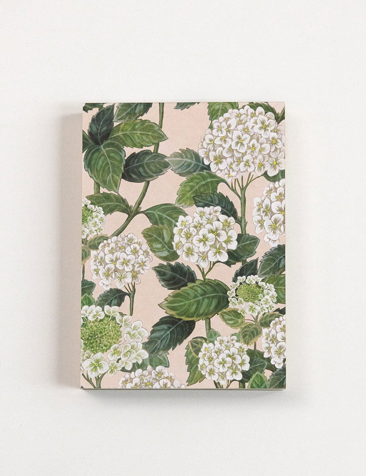 Floral design notebook with green leaves and white flowers on a beige background