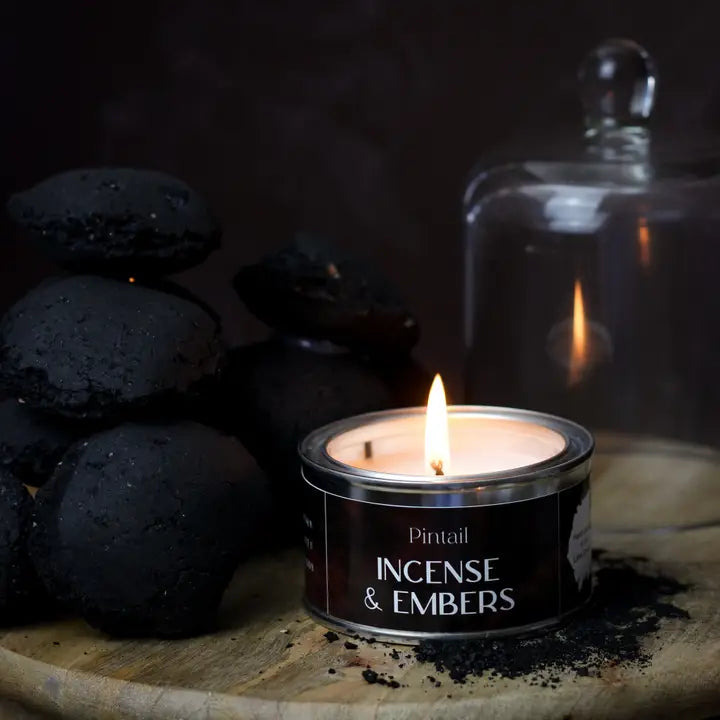 A lit tin candle labeled &