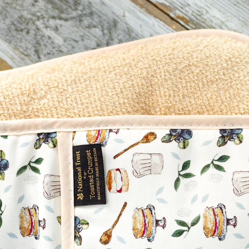 Double oven glove with a pattern of sandwiches, spoons, and leaves on a white background, featuring a National Trust logo.