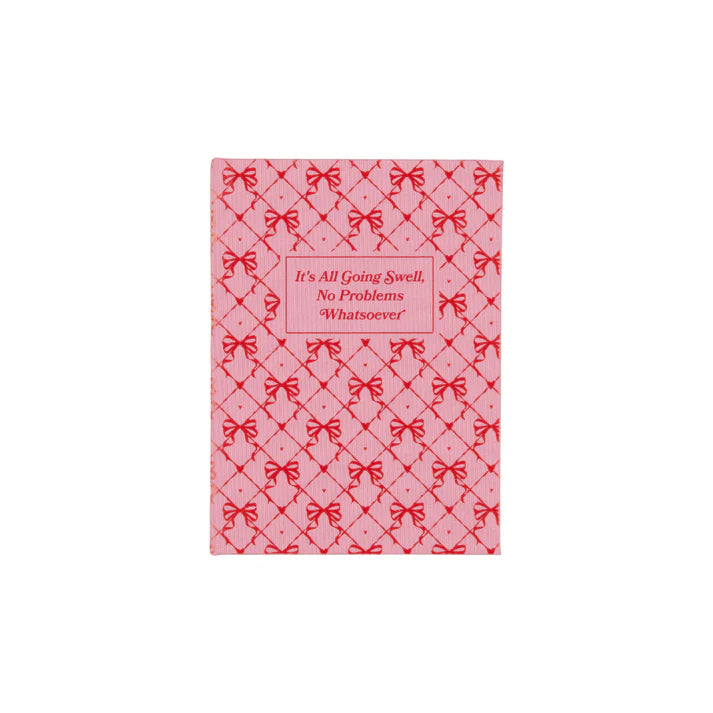 A pink notepad with Its All Going Swell No Problems Whatsoever on the front cover with red bows