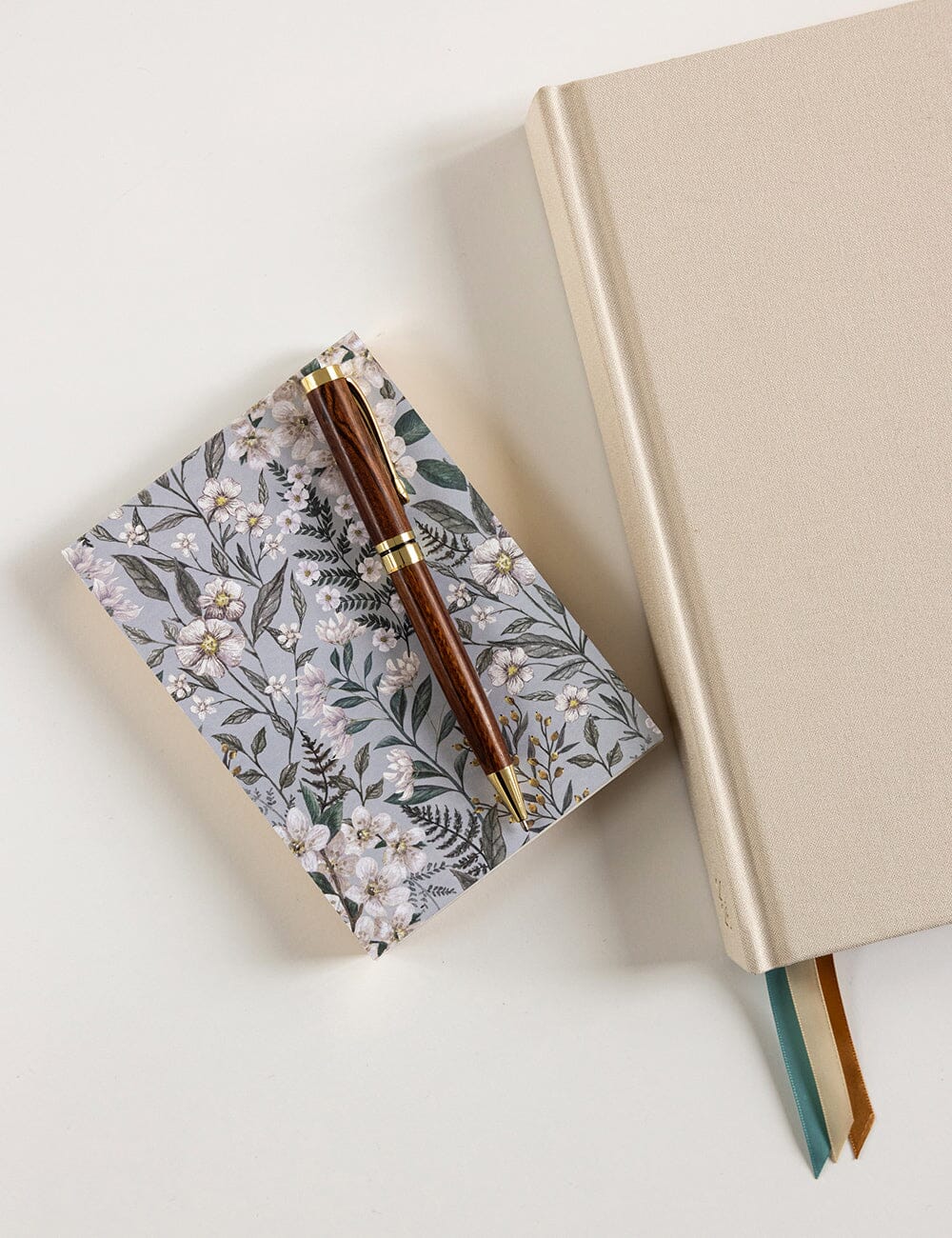 Floral notebook and pen on a light surface