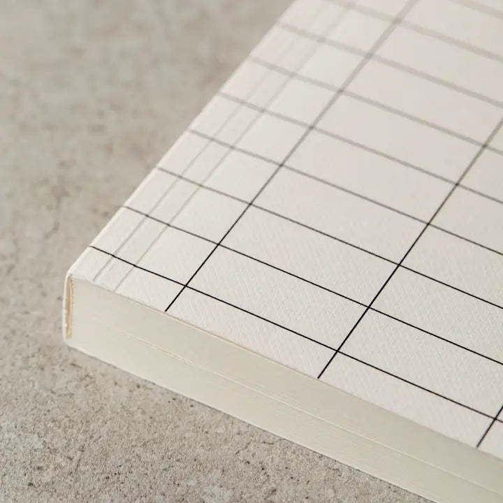 Close-up of a notebook with grid pattern on a textured surface