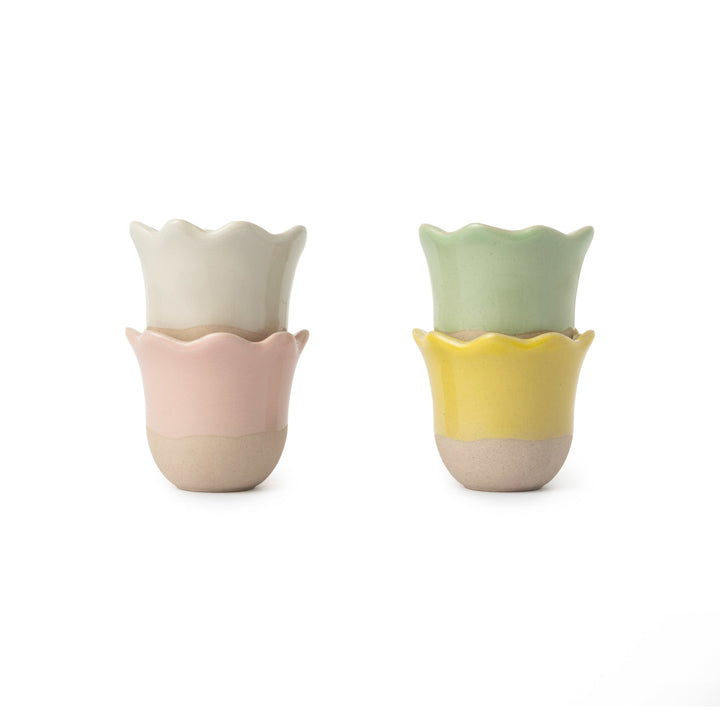 Two ceramic cups with wavy edges in pastel colors on a white background
