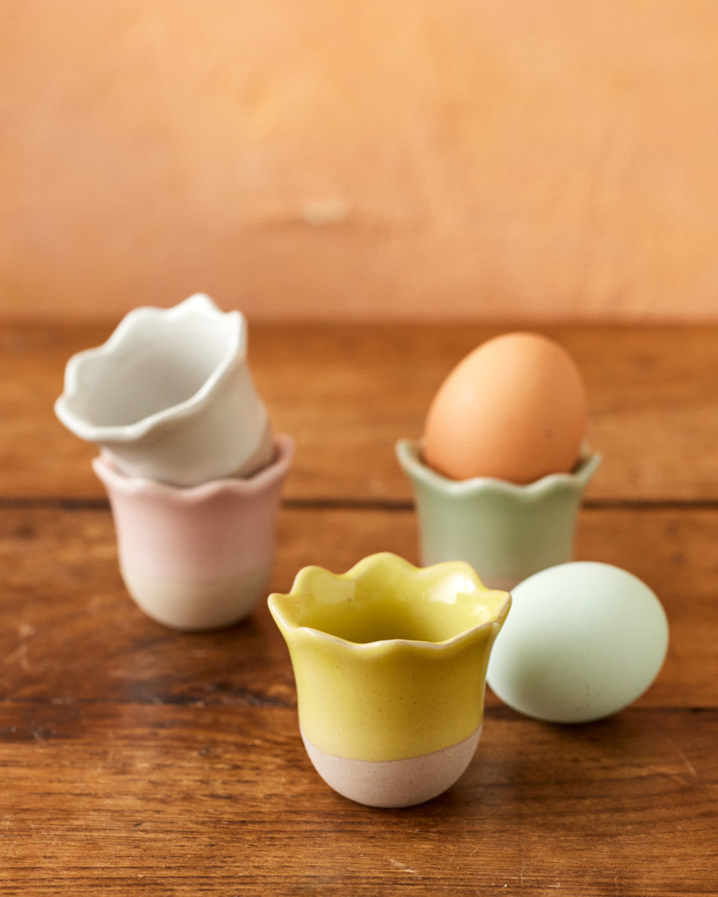 Set of colorful ceramic egg cups on a wooden surface