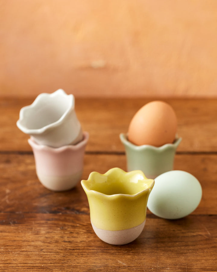 Set of colorful ceramic egg cups on a wooden surface