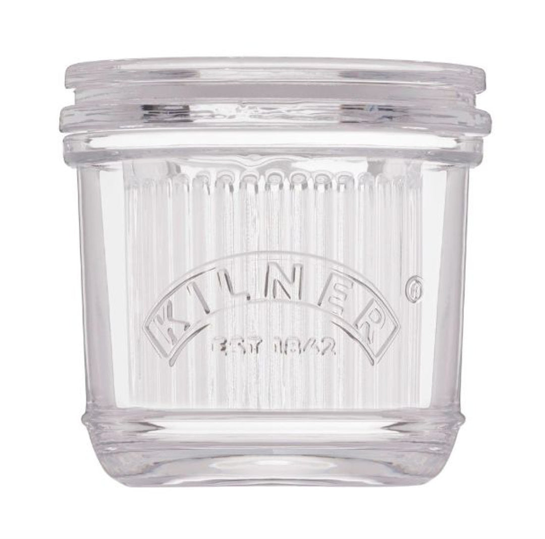 Clear glass butter crock with Kilner logo on a white background