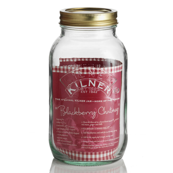 Glass jar with a gold lid and red label on a white background