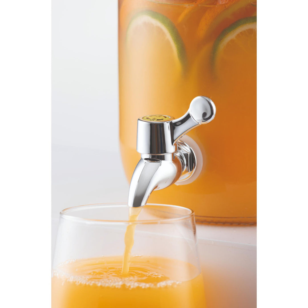 Orange juice being poured from a dispenser into a glass with a blurred background