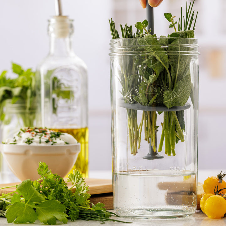 Clear glass container with herbs on a kitchen counter