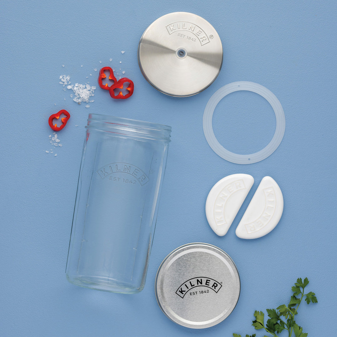 Kilner preserving jar components on a blue background