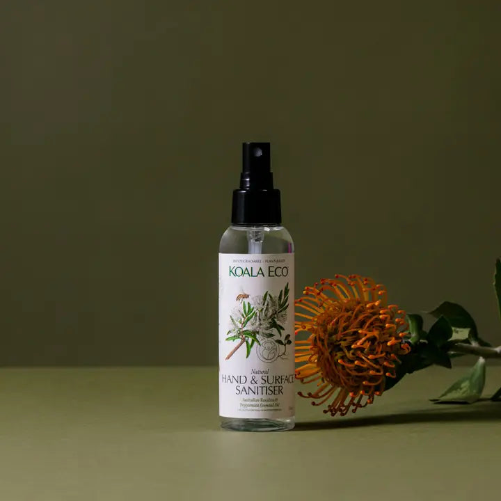 Koala Eco hand and surface sanitizer bottle with a flower on a green background