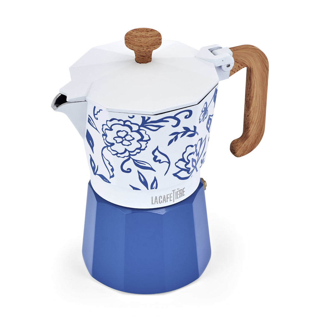 Blue and white coffee maker with floral design and wooden handle on a white background