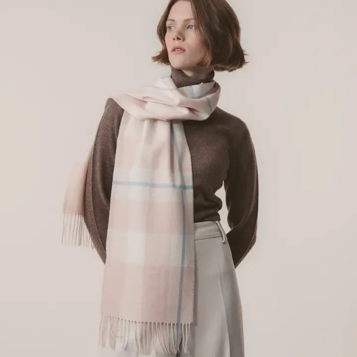 Woman wearing a plaid scarf with a plain background