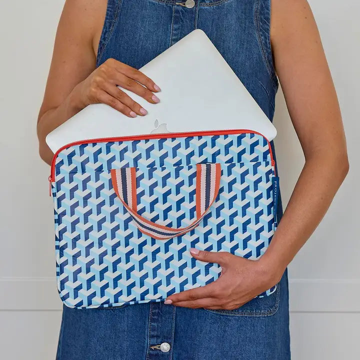 Person holding a blue and white patterned laptop sleeve with red accents.