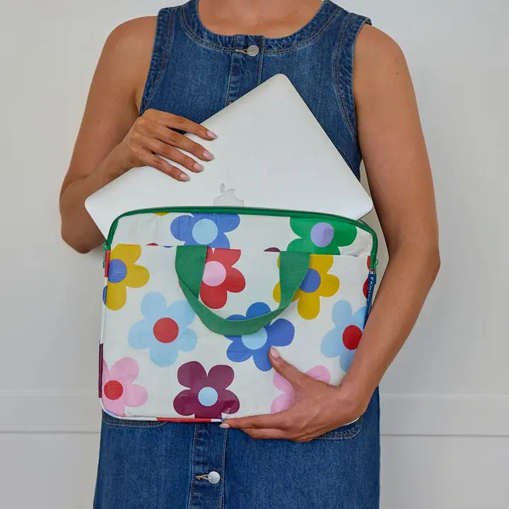 Person holding a colorful floral-patterned bag with a plain background