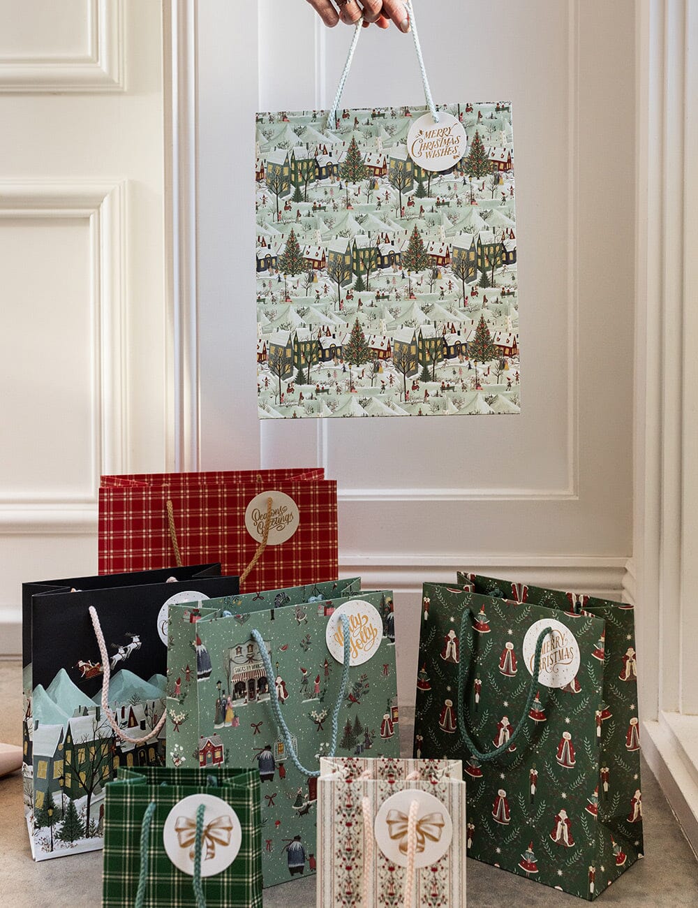 Collection of Christmas-themed gift bags with various designs on a neutral background.