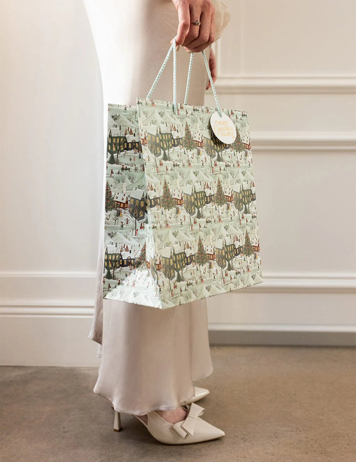 Person holding a patterned bag against a neutral background