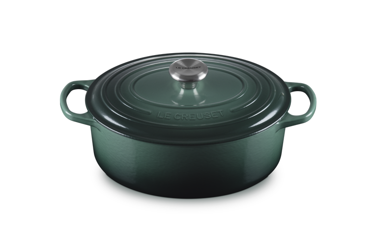 Green cast iron cookware pot with lid on a white background