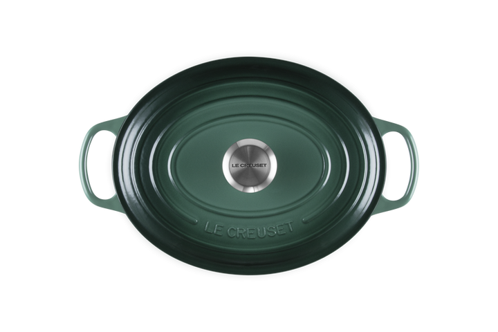 Green cast iron cookware with 'Le Creuset' branding on a white background