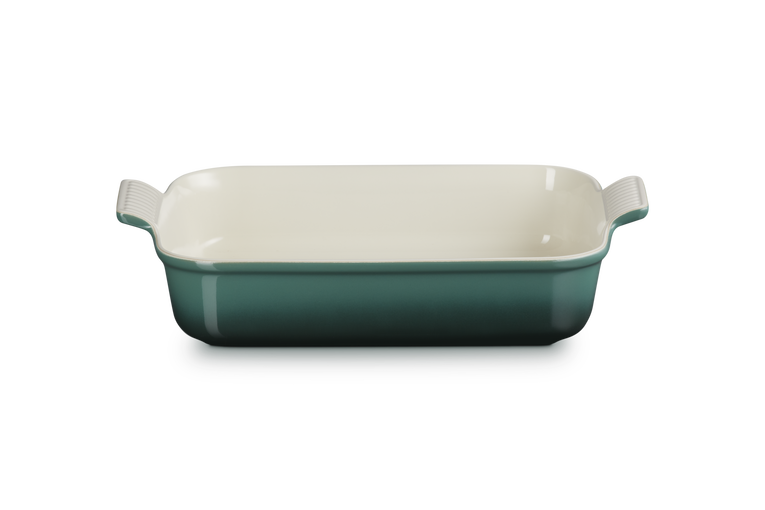 Rectangular baking dish with green exterior and white interior on a white background