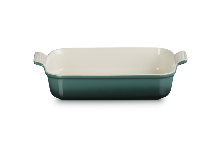 Rectangular baking dish with green exterior and white interior on a white background